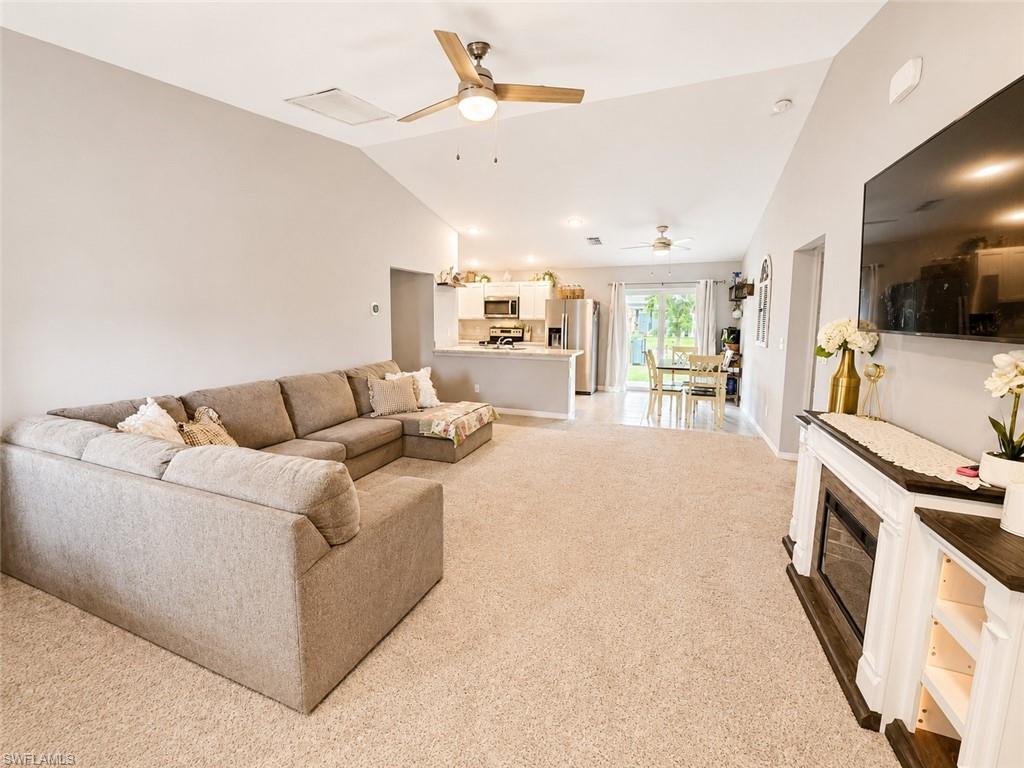 Vaulted ceiling with a ceiling fan, recessed lighting, and soft carpet flooring