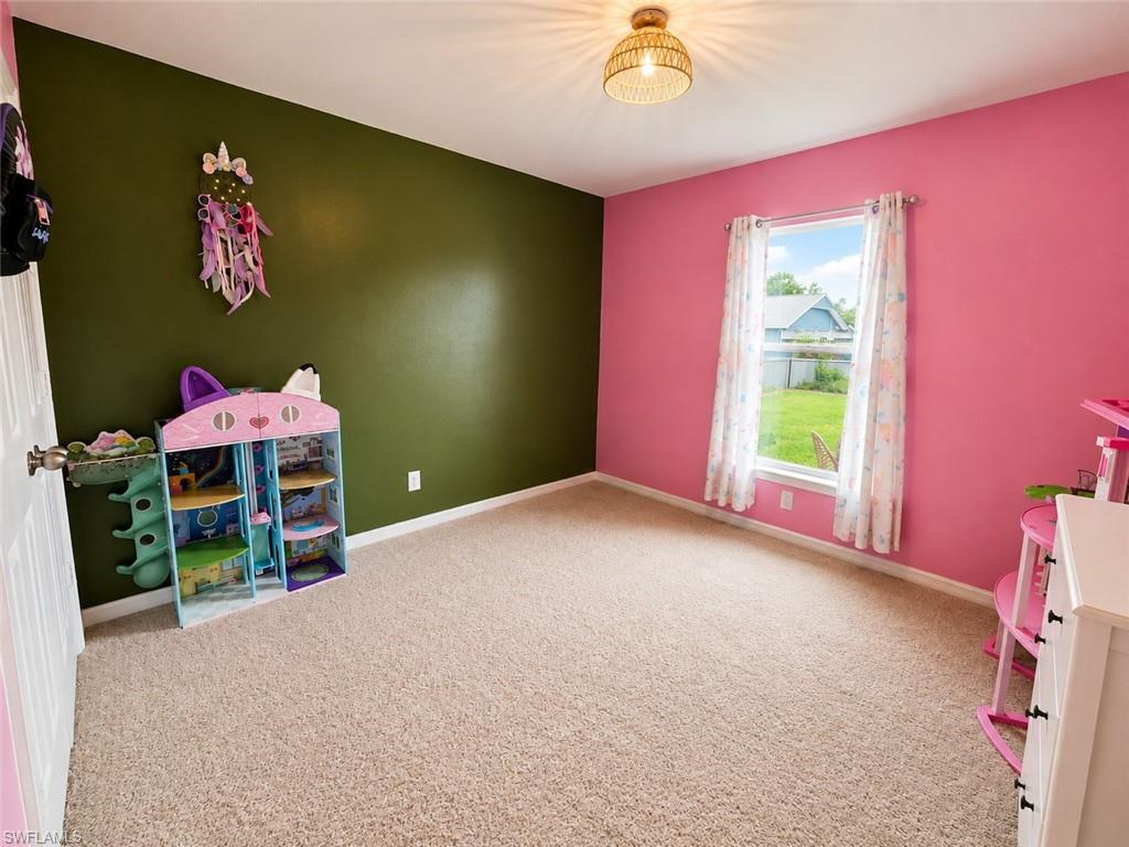 Textured carpeting, single window with white trim, recessed lighting, and mixed wall finishes