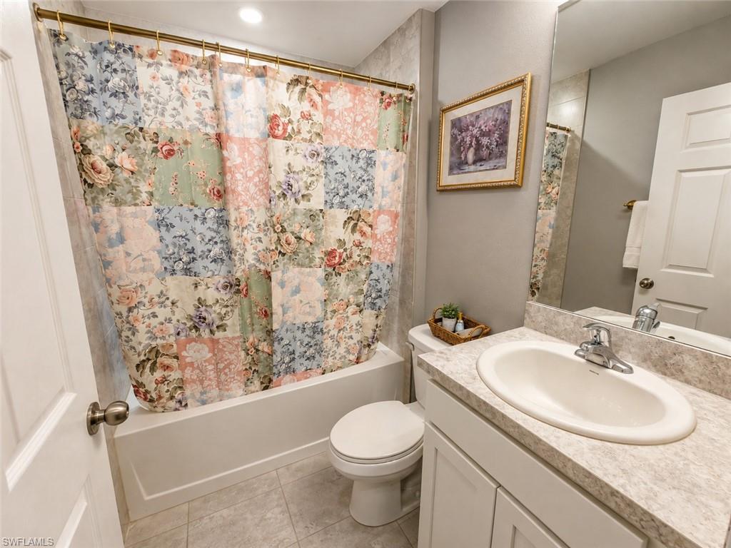 Bathroom featuring a white vanity with an integrated sink, polished chrome faucet, and a wall-mounted mirror