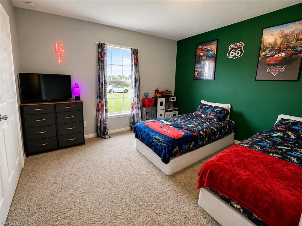 Carpeted flooring, dual-tone wall paint, and a window with trim