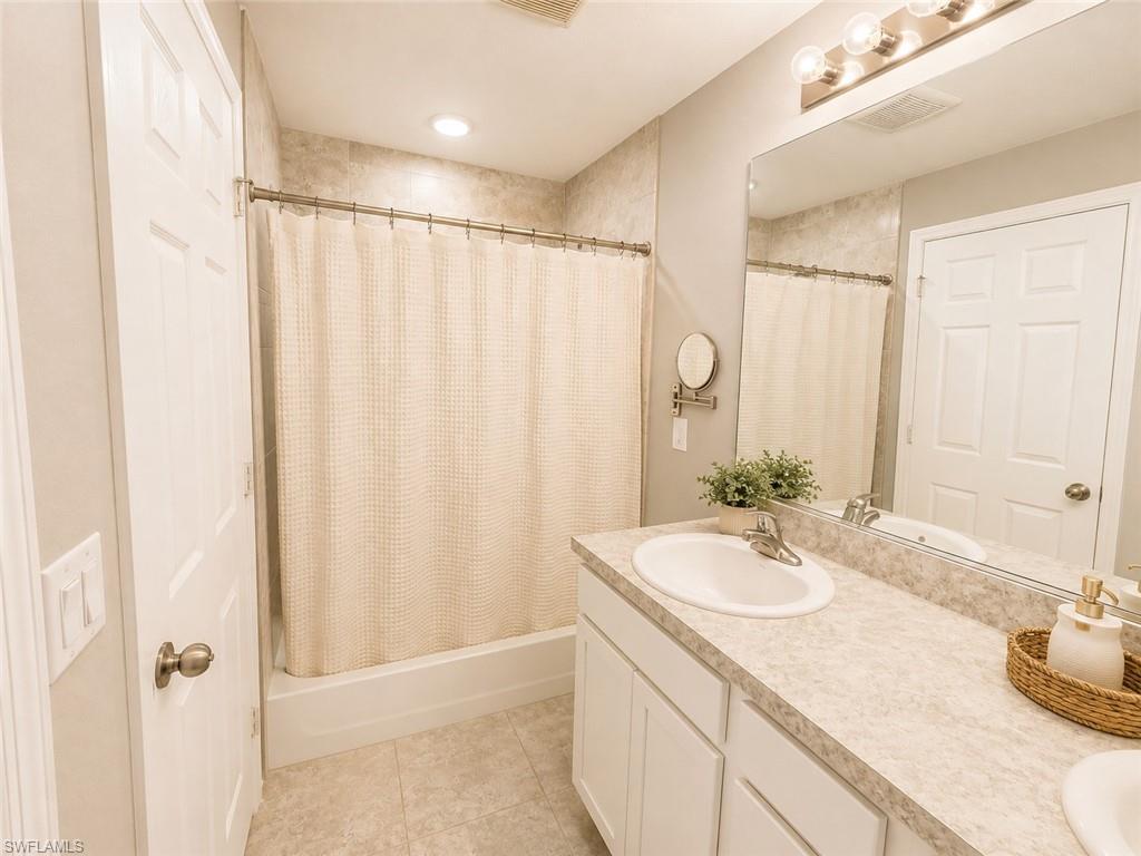 Full vanity with integrated sink, overhead mirror, and light fixture