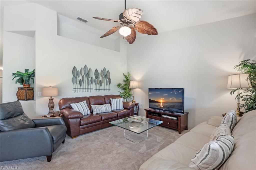 Living area featuring carpet and a ceiling fan