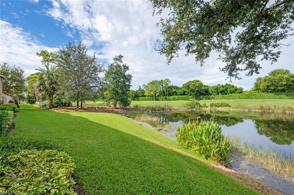 View of green lawn featuring a water view