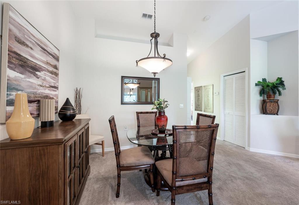 Dining room featuring light colored carpet and high vaulted ceiling