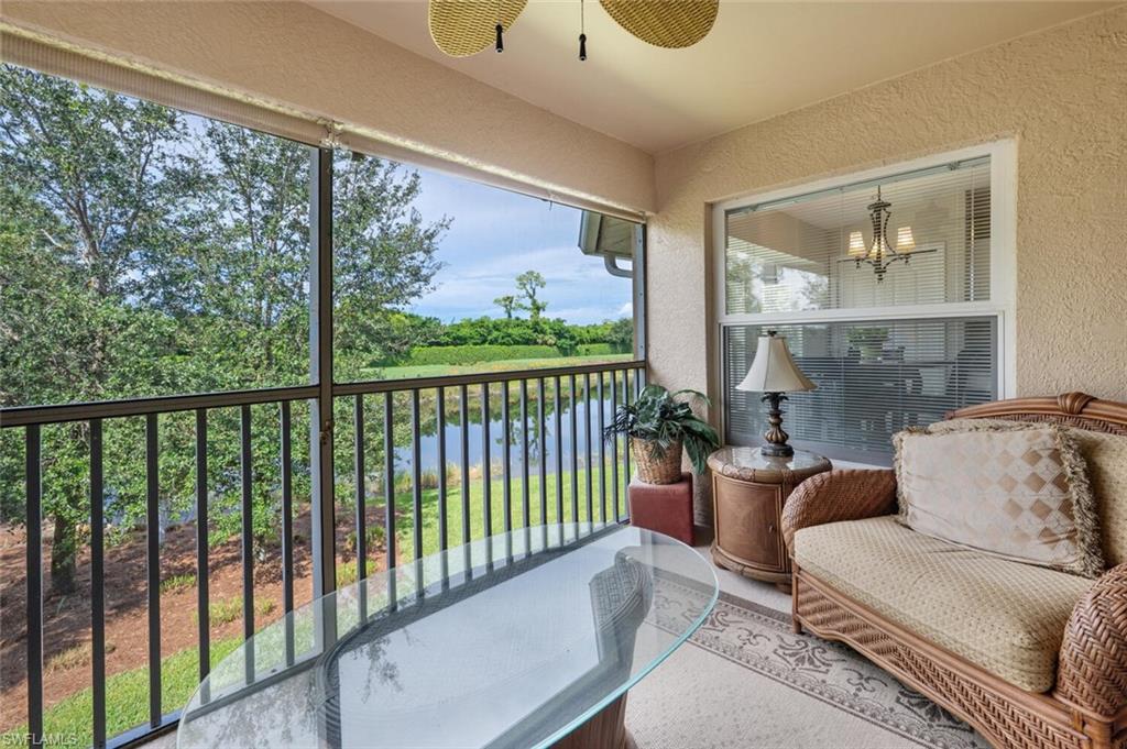 Balcony featuring a water view and a ceiling fan