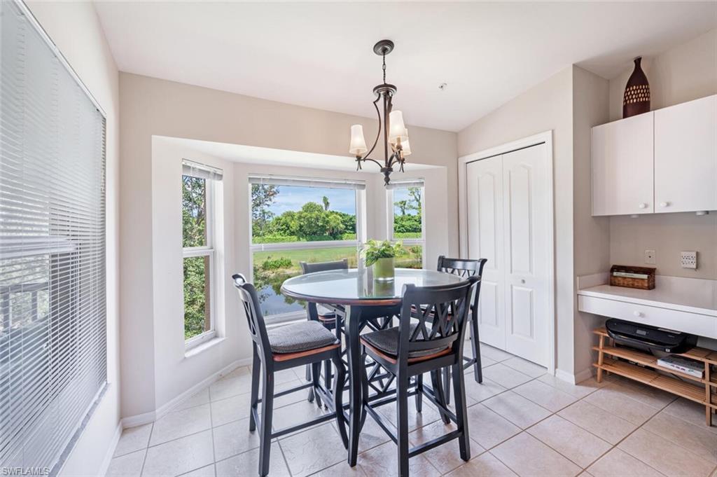 Dining area with plenty of natural light, light tile patterned floors, and a chandelier