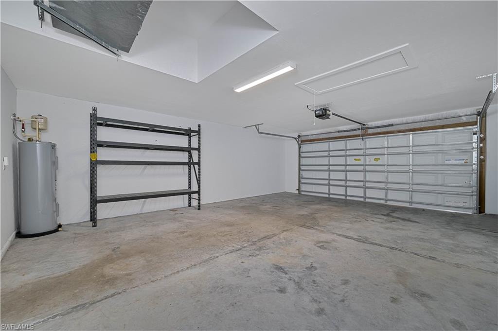 Spacious 2-car garage with storage shelving, attic access, and plenty of room for vehicles, tools, and additional storage.