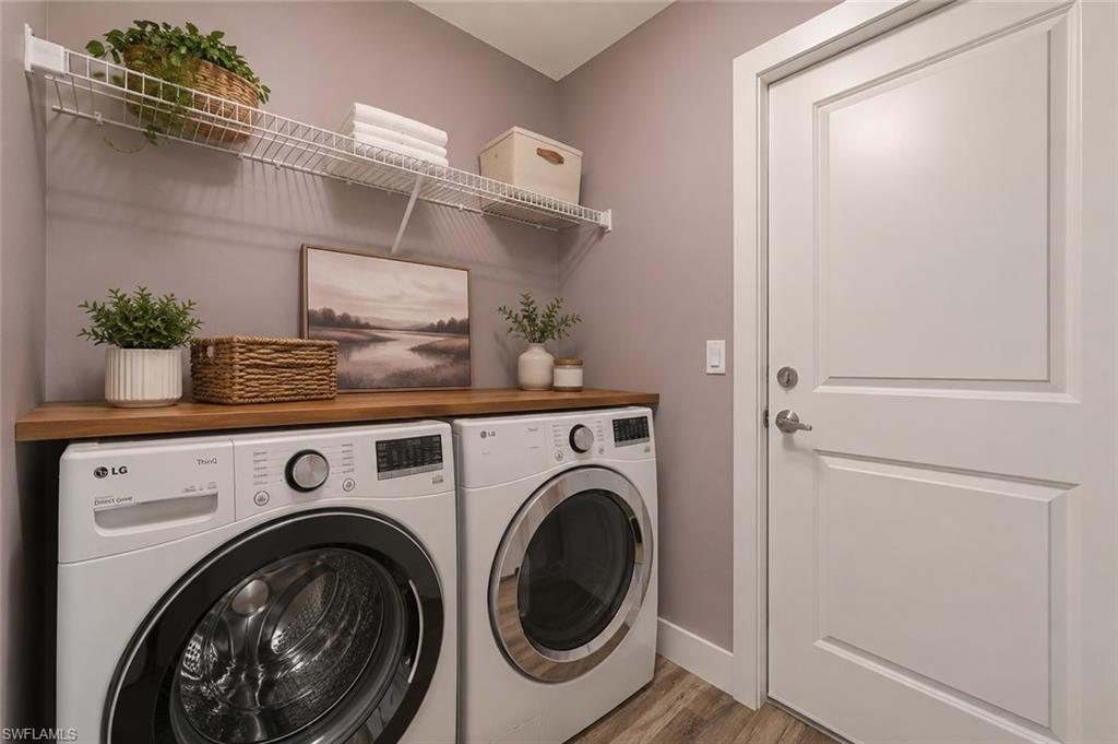 Convenient indoor laundry room with washer and dryer, hook up, built-in shelving, and extra storage space to keep household essentials organized. [Virtually Staged]