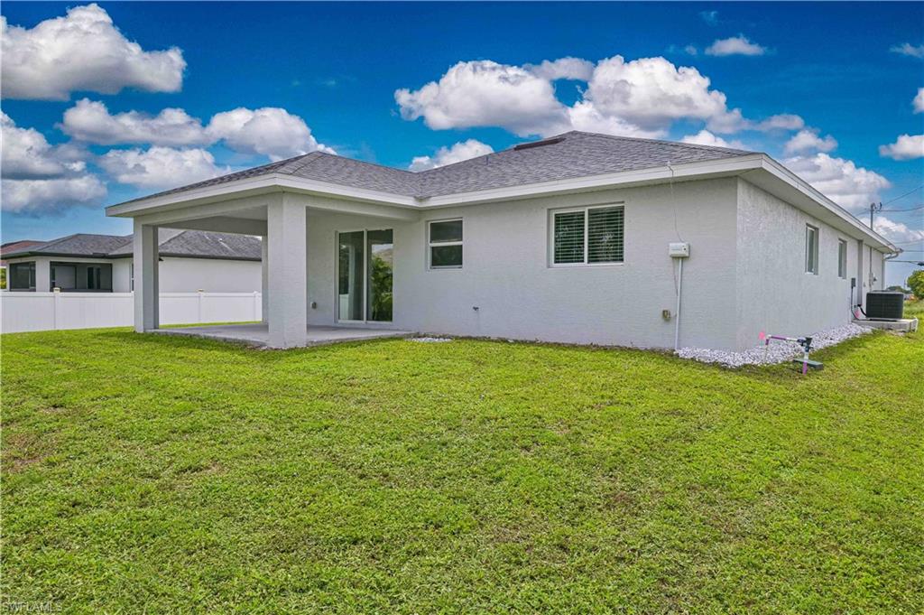 Spacious rear exterior with a covered lanai and generous backyard, offering endless possibilities for outdoor living, entertaining, or adding a custom pool.