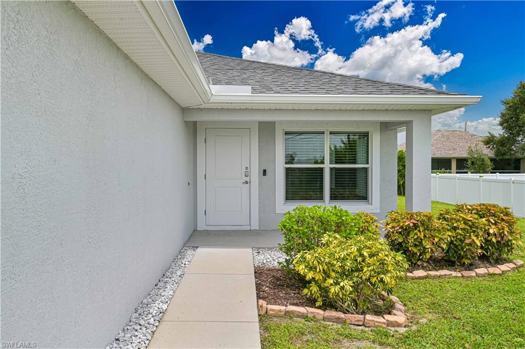 Welcoming covered front entry with attractive landscaping and a sheltered porch that enhances the home's curb appeal.