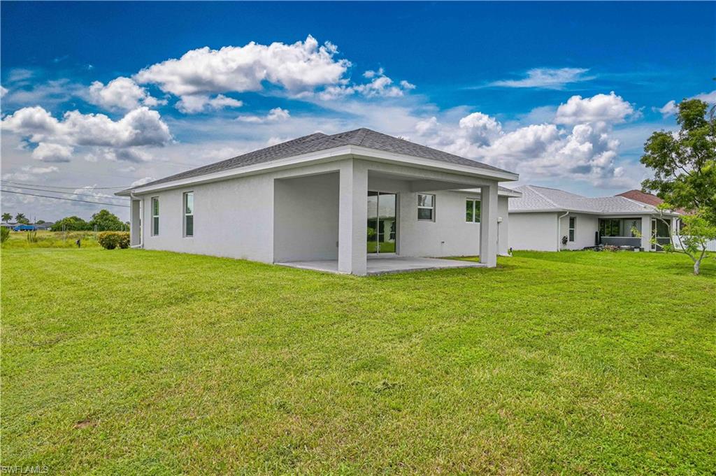 Rear exterior showcases the covered lanai and expansive backyard with plenty of space for a future pool, entertaining, or outdoor enjoyment.
