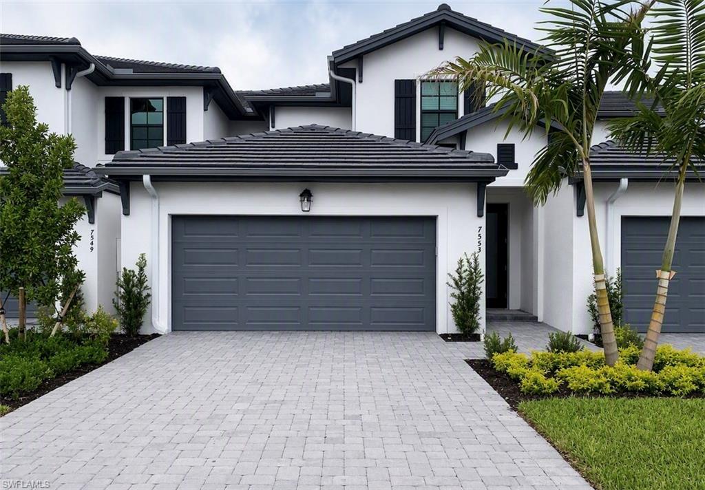 White stucco exterior with a dark tile roof