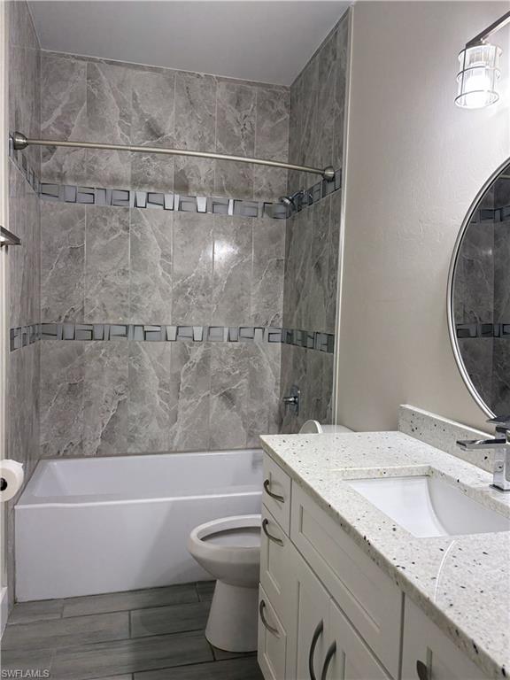 Shower-over-tub design with grey-toned tile surround and decorative accent band