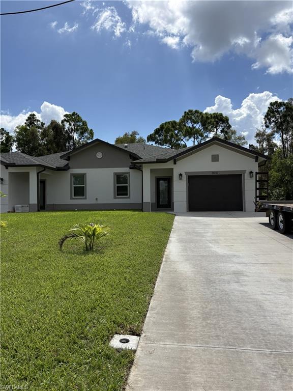 Contemporary one-story home featuring a two-car garage, concrete driveway, and a well-maintained front lawn