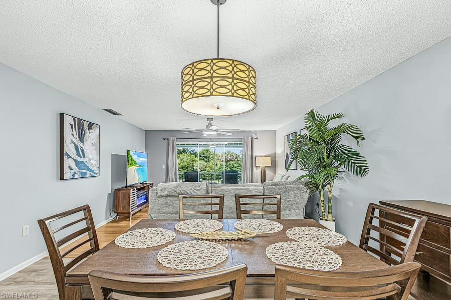 Dining area with a drum pendant light fixture and wood-finish flooring