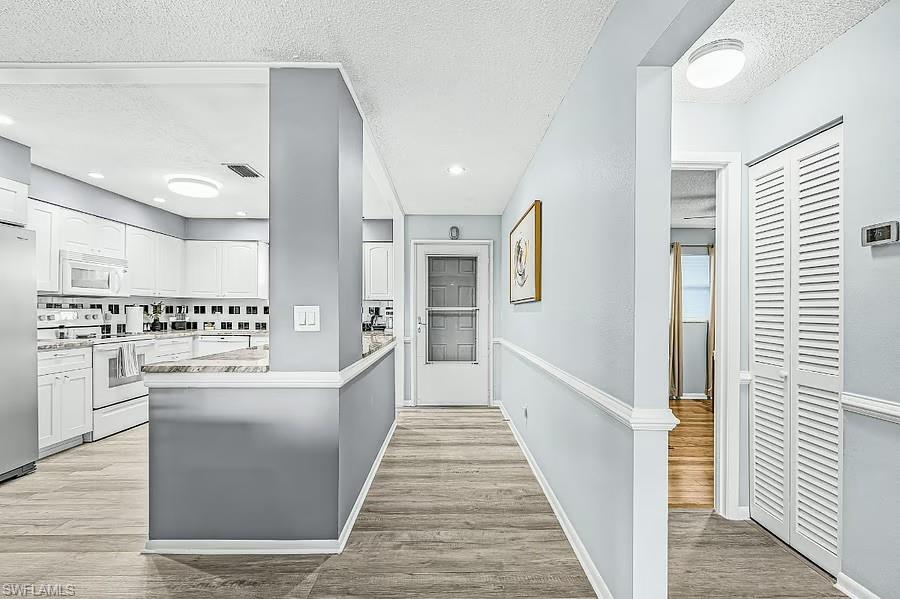 Kitchen with white cabinetry, stainless steel appliances, and a tiled backsplash