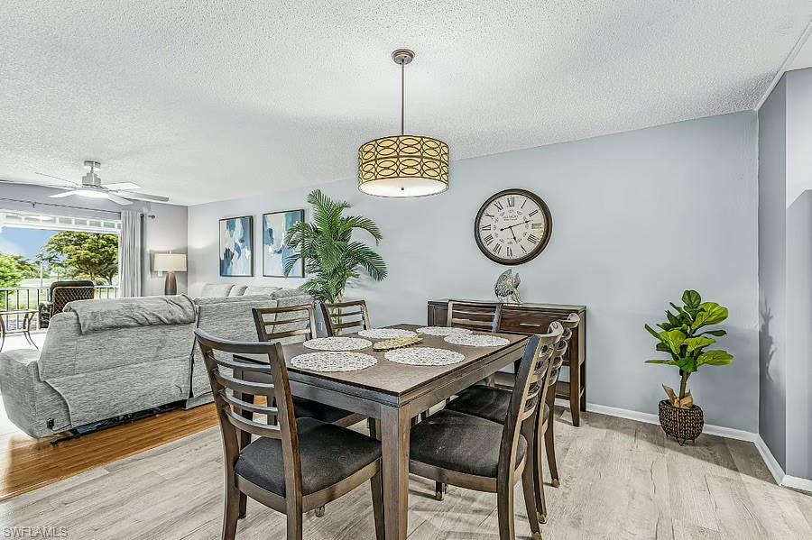 Open-concept dining area with wood-finish flooring, a contemporary chandelier, and a serving console