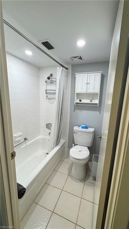 White subway tile shower surround with a built-in tub, square tile flooring, and recessed ceiling lighting