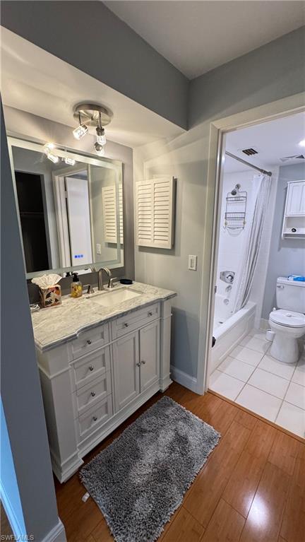 White vanity with a stone countertop, under-mount sink, and brushed nickel faucet
