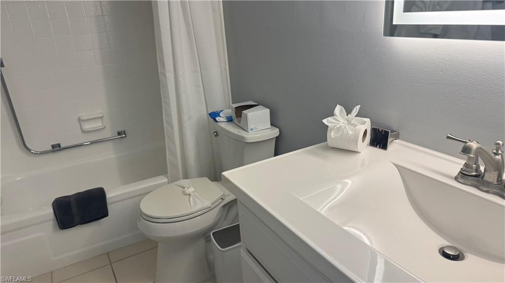 White vanity with integrated sink, brushed nickel faucet, and illuminated mirror