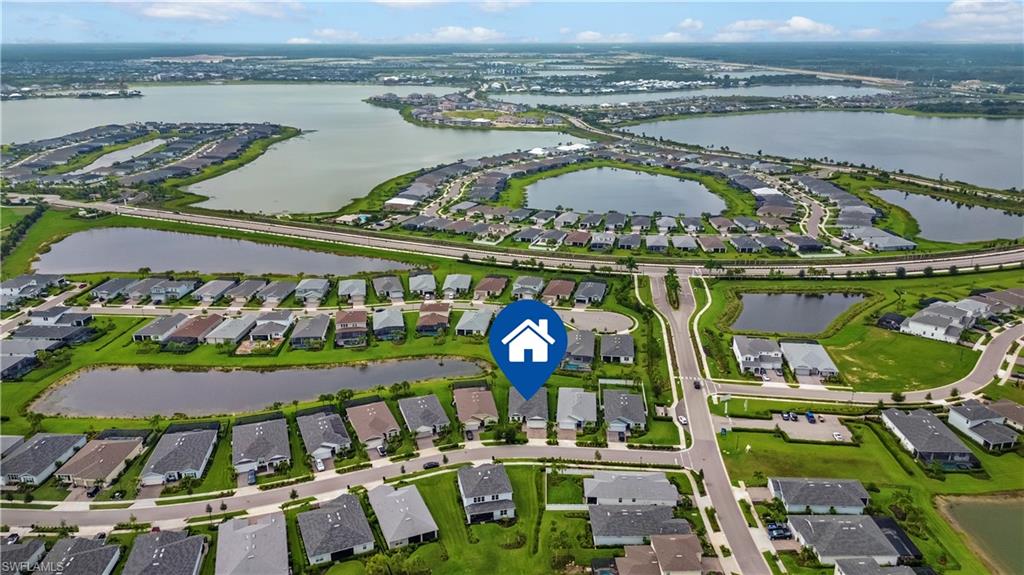 Aerial perspective of a developed residential community featuring multiple water bodies, paved roads, and organized housing layouts