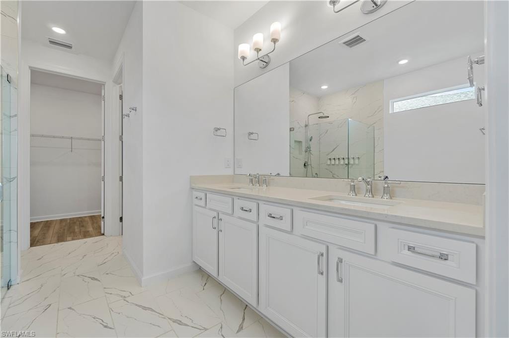Dual vanity with undermount sinks, stone-finish countertop, and chrome fixtures