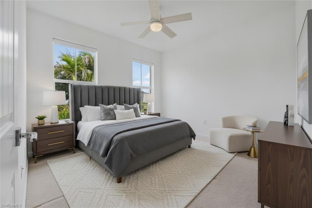 Spacious room with dual windows, overhead ceiling fan, and carpeted flooring