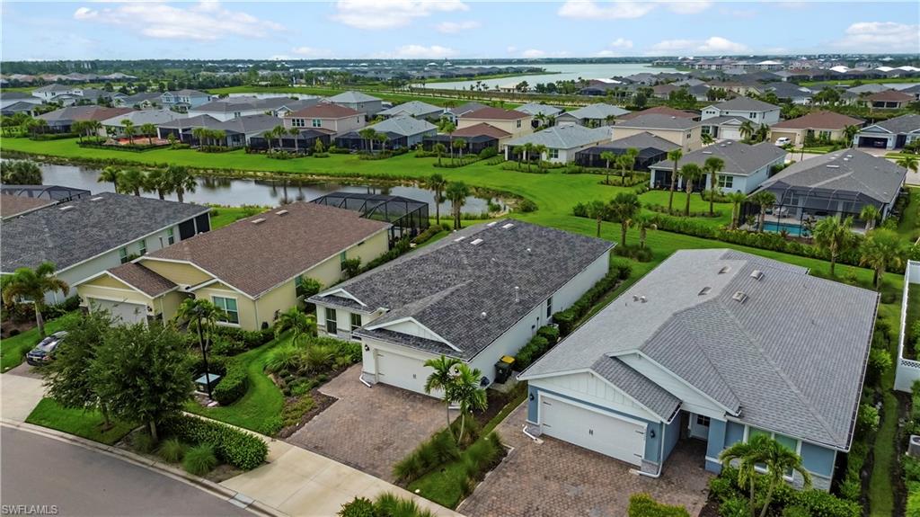 Waterfront community with lush landscaping, paved driveways, and various architectural styles