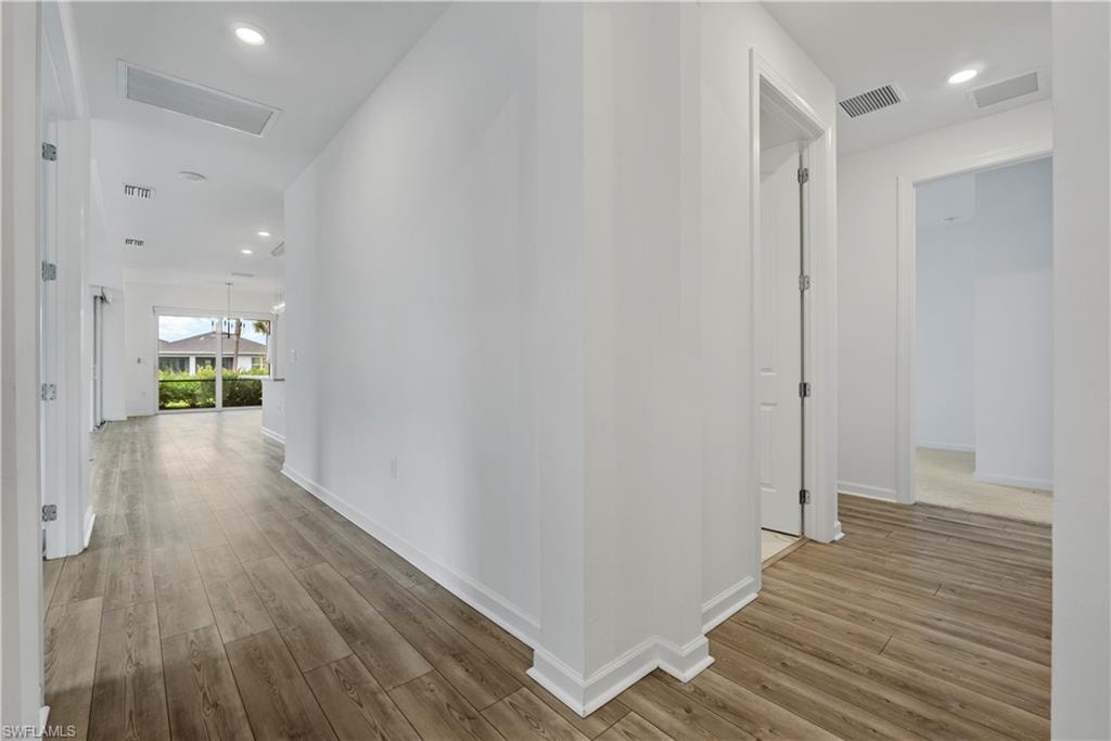 Wood-finish flooring throughout, recessed lighting, and a white wall finish