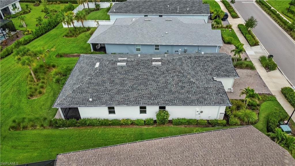 Pitched shingle roof, white exterior siding, screened patio, multiple rear windows, and landscaping
