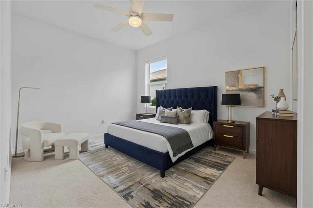 Vaulted ceiling with a ceiling fan, window with exterior elements, and neutral carpeting