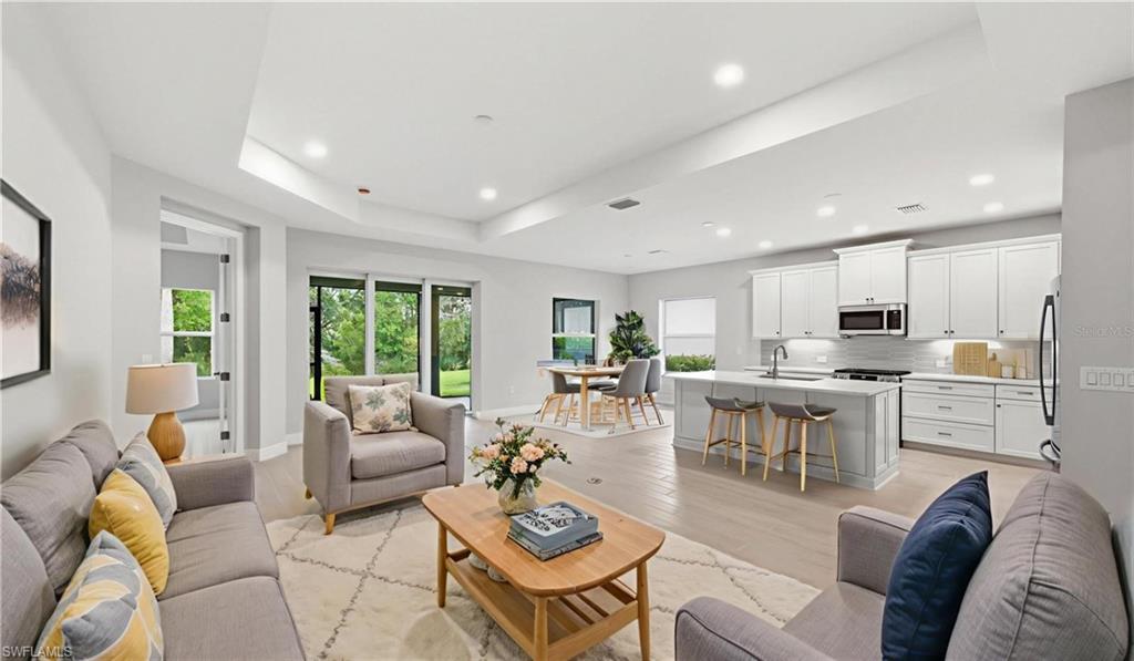 From this angle, the impressive scale of the living area becomes even more apparent. Large-format flooring, elegant tray ceilings, and a clean, contemporary design provide a timeless backdrop for any décor style. Natural light filters throughout the space, enhancing the home's fresh, move-in-ready appeal and creating an ideal setting for both quiet mornings and lively gatherings.