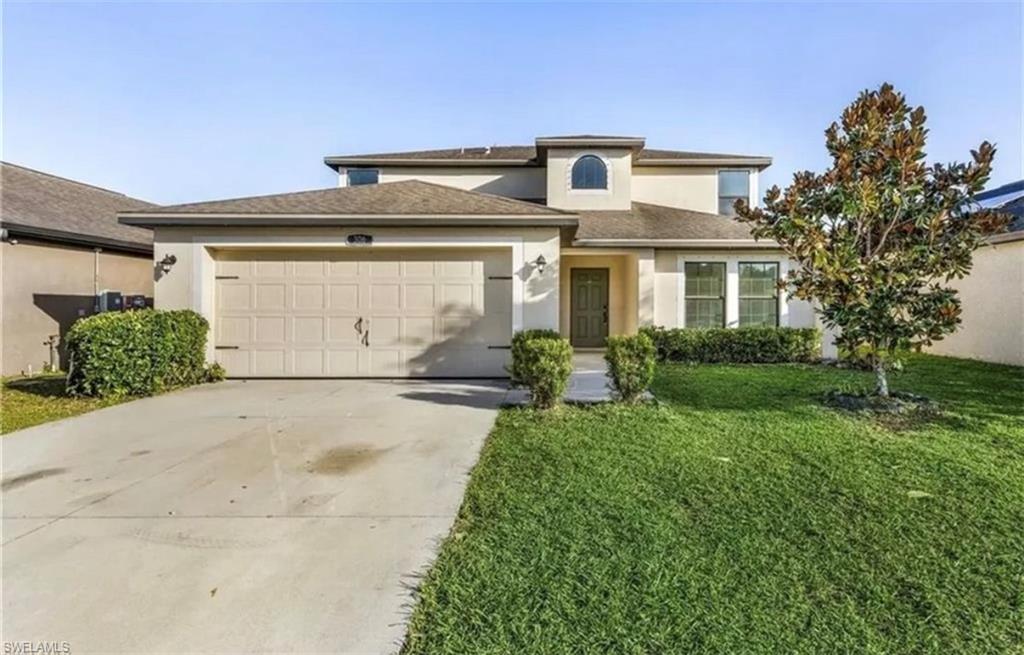 Stucco exterior with an arched window accent, an attached garage, and a concrete driveway
