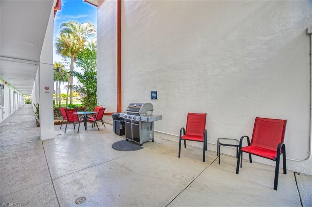 Outdoor patio area featuring a stainless steel grill, a round dining table, and concrete flooring