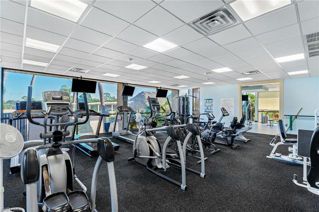 Fitness center featuring a rubberized floor and drop ceiling