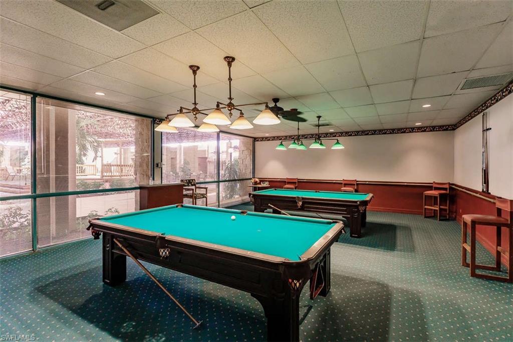 Recreation space featuring two billiard tables, recessed lighting, drop ceiling, and large windows with roller shades