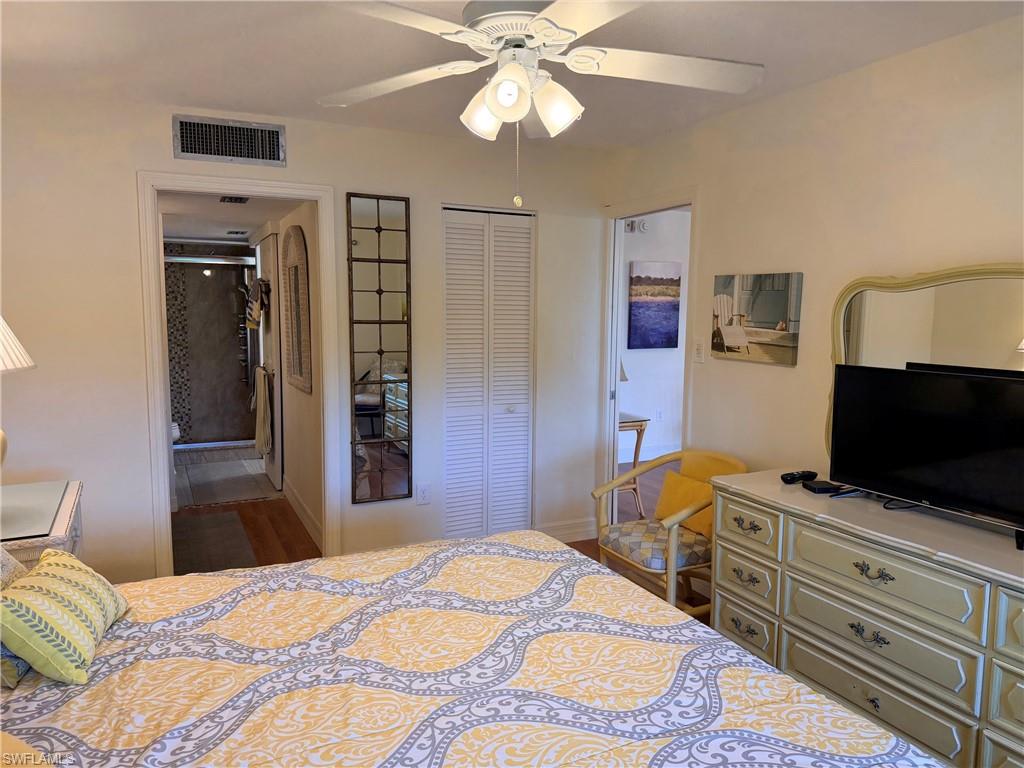 Recessed lighting, ceiling fan with integrated light fixture, louvered closet doors, and wood-finish flooring