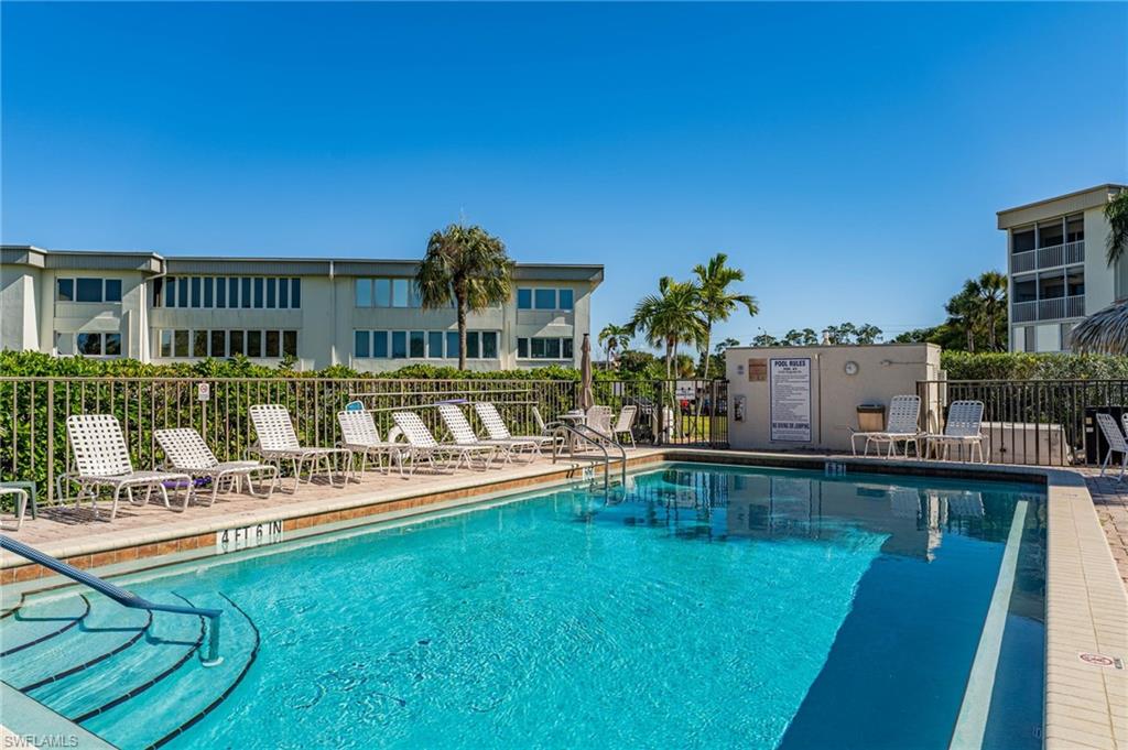 Inviting swimming pool with integrated steps, surrounded by a paver deck, and secured by a perimeter fence