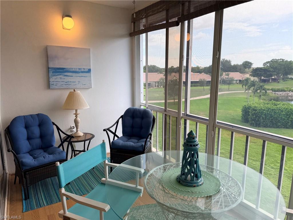 Screened enclosure with expansive outdoor scenery, wood-finish flooring, and wall-mounted lighting