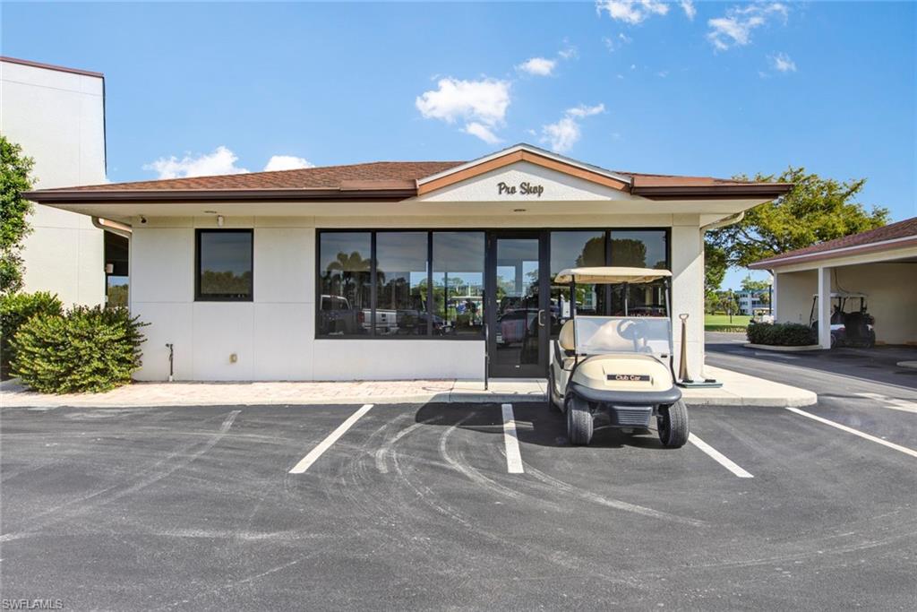 Pro Shop building with a pitched roof, large storefront windows, and an adjacent covered parking area