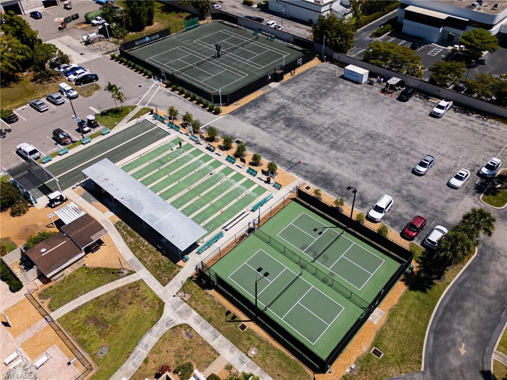Multiple tennis courts, dedicated pickleball courts, manicured lawn bowling greens, paved parking areas, and mature landscaping