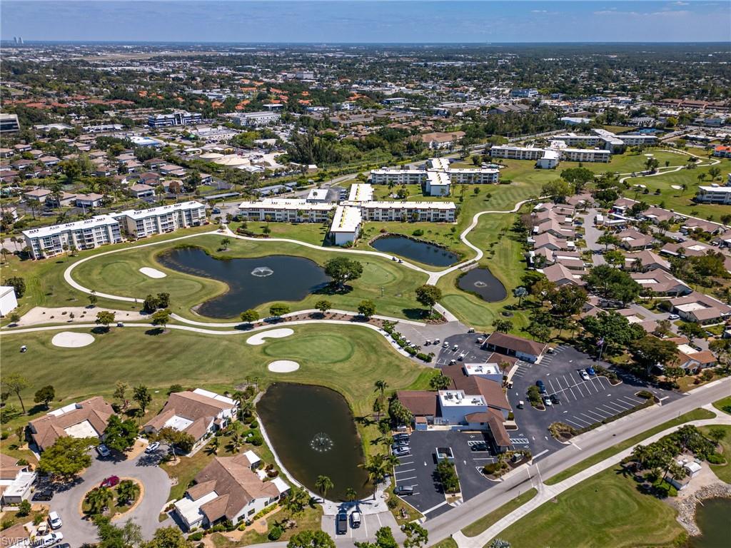 Expansive golf course setting featuring multiple water features, manicured greens, and a paved road network