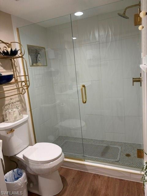 Glass-enclosed shower with gold-finish hardware, white subway tile surround, and mosaic tile flooring