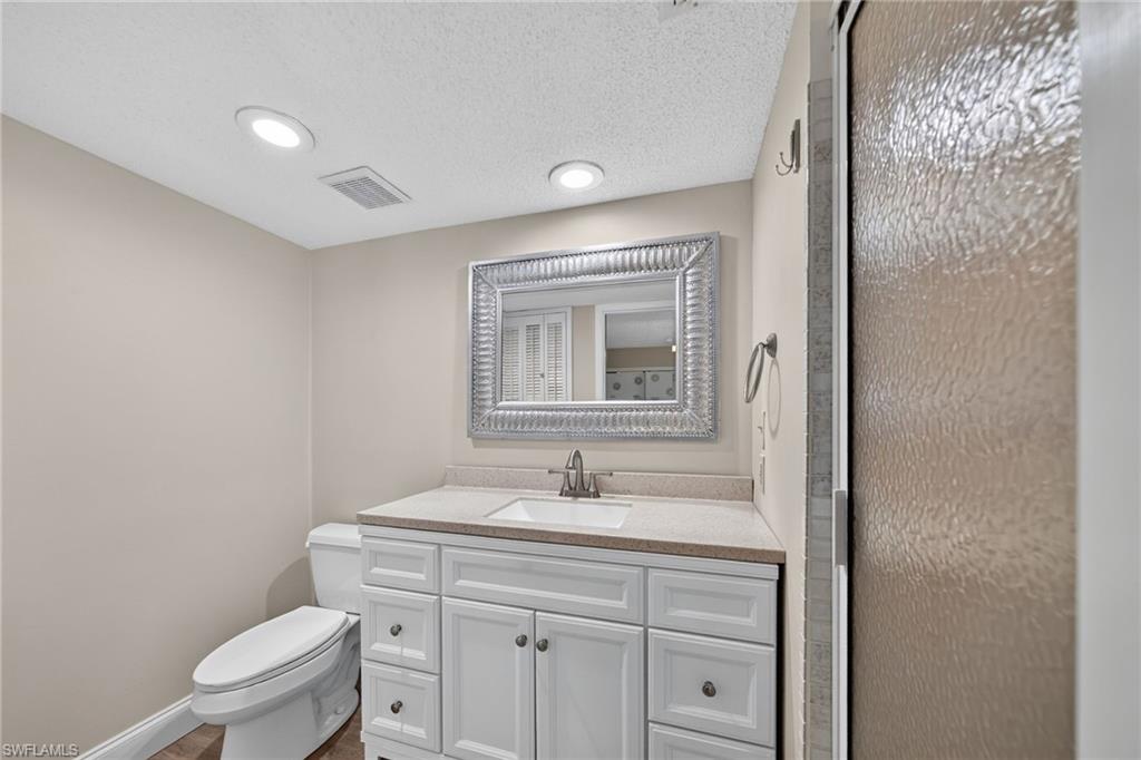 Primary bathroom with marble vanity with shaker-style cabinetry, a built-in rectangular sink, and a light-toned countertop