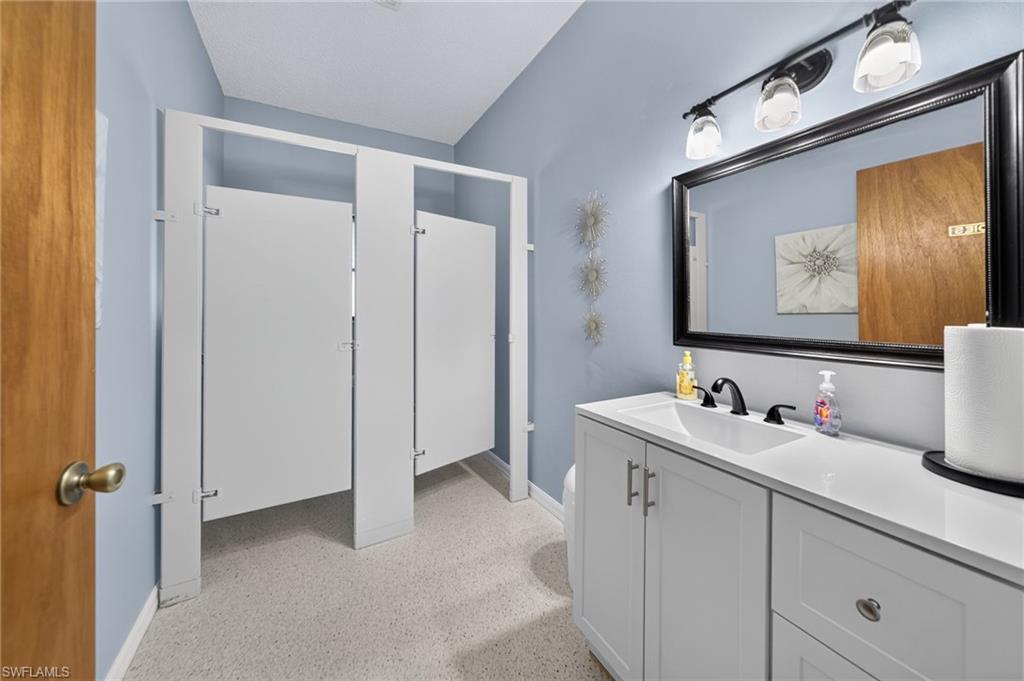 White vanity with an integrated sink, matte black faucet, and a large framed mirror