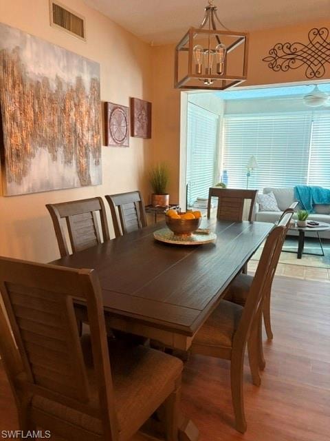 Dining area featuring luxury vinyl flooring and a contemporary chandelier