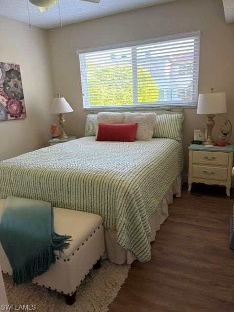 Guest quarters  featuring a large window with horizontal blinds, wood-finish flooring, and a ceiling fan