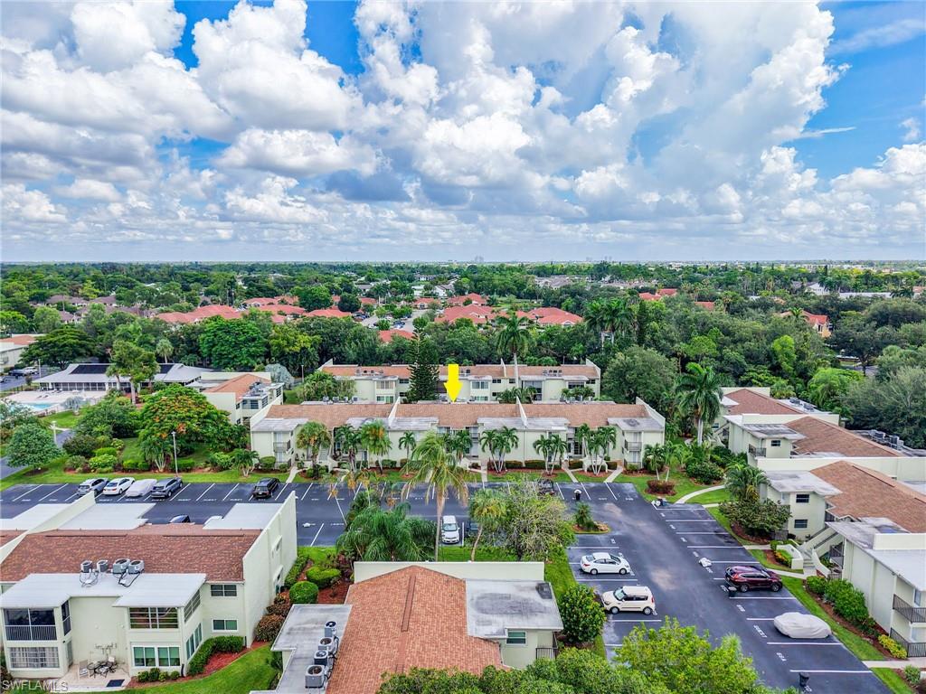 Additional Mature landscaping, expansive parking areas, multiple residential buildings, and abundant tree canopy