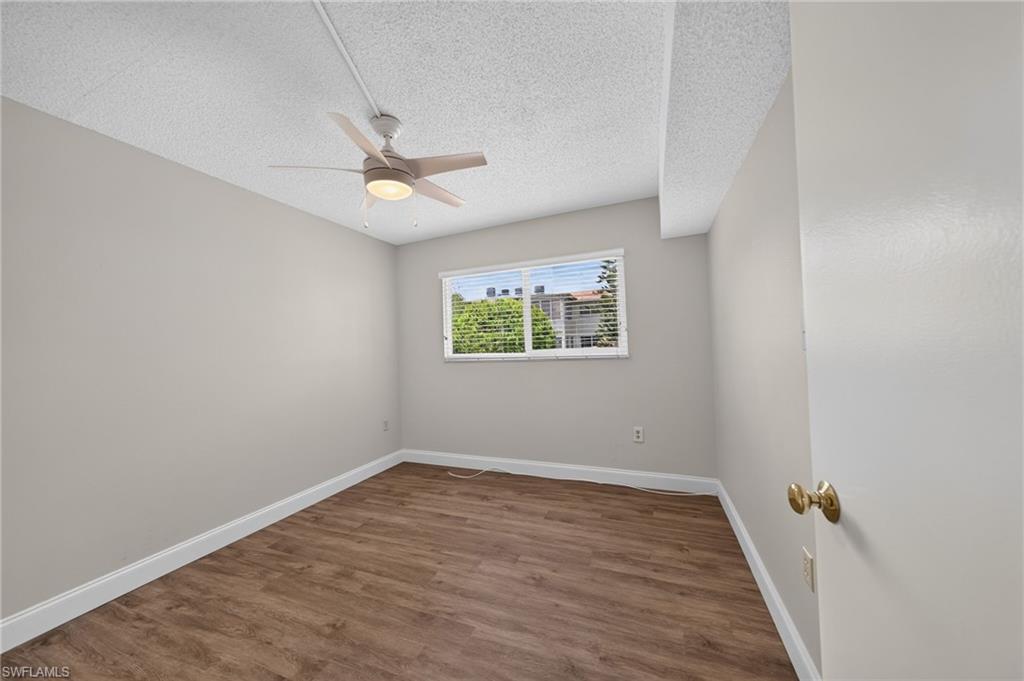Guest quarters, neutral wall tones, ceiling fan with integrated lighting, and a white-framed window