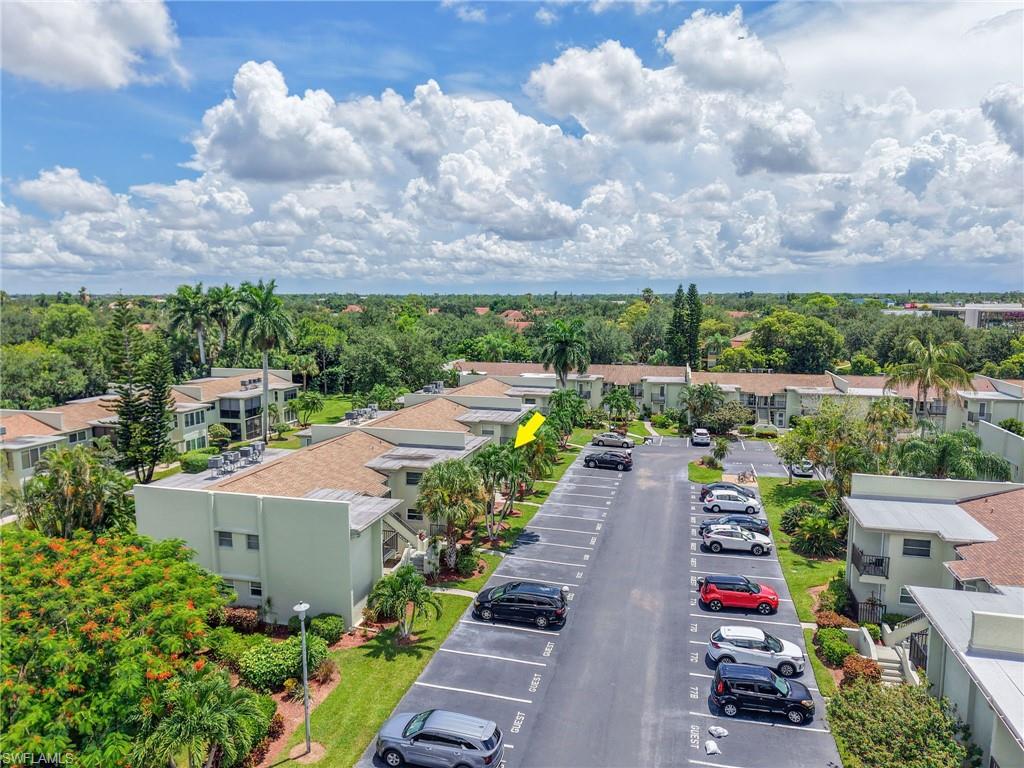 Additional conLush tropical landscaping surrounds the property, featuring a paved parking area with designated guest spacestent